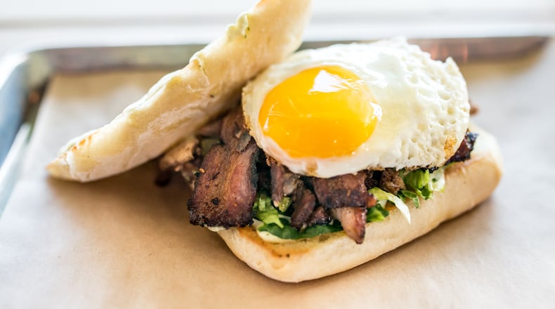 Triple Torta with three kinds of meat, lettuce, avocado aioli, and a fried egg on bread at Porch Light Latin Kitchen. Photo Credit- Mia Yakel. Styling Credit- Chef Andre Gomez