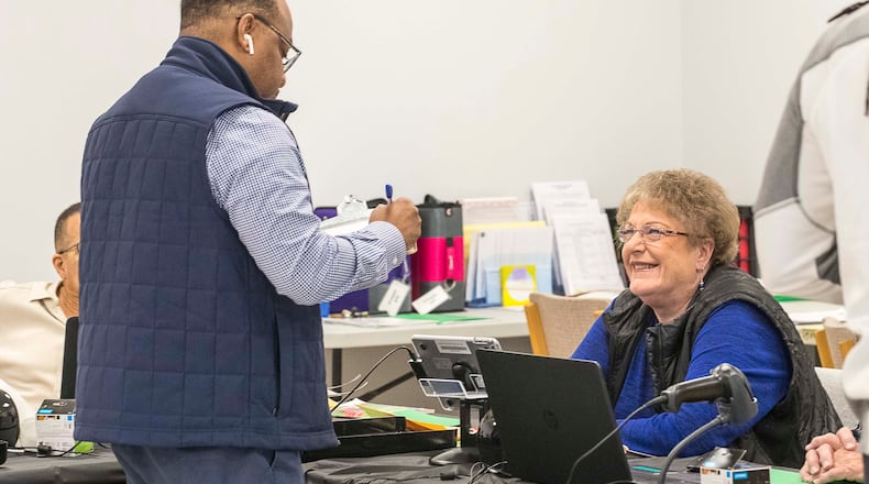 03/02/2020 -- Lawrenceville, Georgia -- Gwinnett County poll worker Judy Rhea (right) assist an early voter during early voting for the presidential primary at the Gwinnett Voter Registrations and Elections office building in Lawrenceville, Monday, March 2, 2020. (ALYSSA POINTER/ALYSSA.POINTER@AJC.COM)