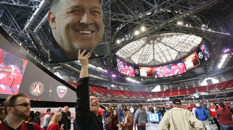 Founders Club member Tim Tewell from East Cobb shows his support for Atlanta United by holding a 'Tata' Martino banner from the 100 concourse in Mercedes-Benz Stadium on March 11, 2018 in Atlanta Ga.