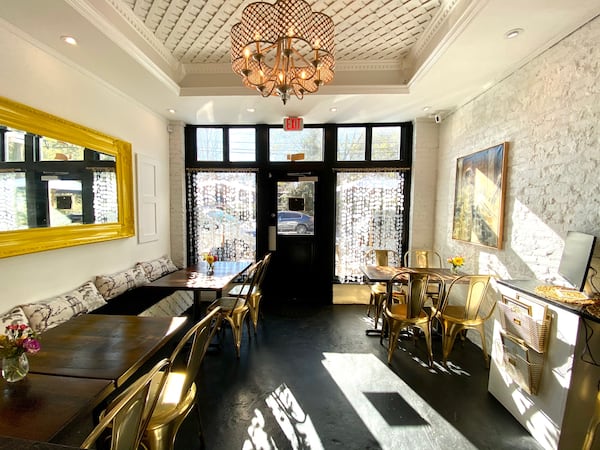 A brightly lit interior of a small restaurant, looking outward toward the front door.