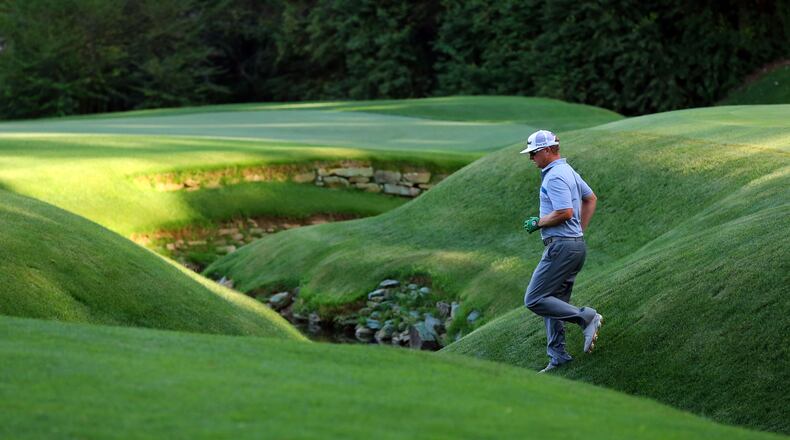 Charley Hoffman crosses a tributary to Rae’s Creek on the No. 13 green during last year’s Masters. CURTIS COMPTON/CCOMPTON@AJC.COM