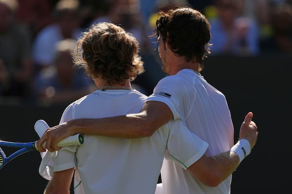 Andrey Rublev of Russia, left, embraces Lloyd Harris of South Africa at the net after winning their second round men's singles match at the Wimbledon Tennis Championships in London, Wednesday, July 2, 2025. (AP Photo/Joanna Chan)