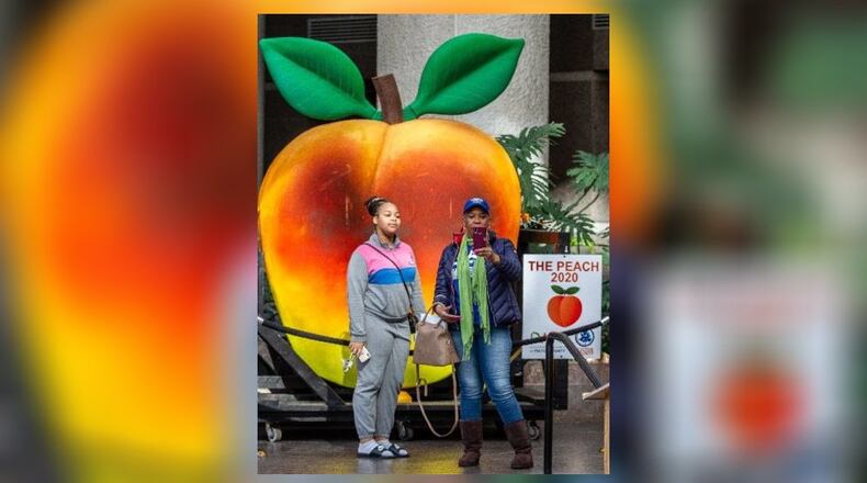 Joya Poole and her granddaughter Kayla Hays take a selfie in front of the peach from Atlanta’s annual Peach Drop in the atrium of the Fulton County Government Center December 31, 2019. STEVE SCHAEFER / SPECIAL TO THE AJC