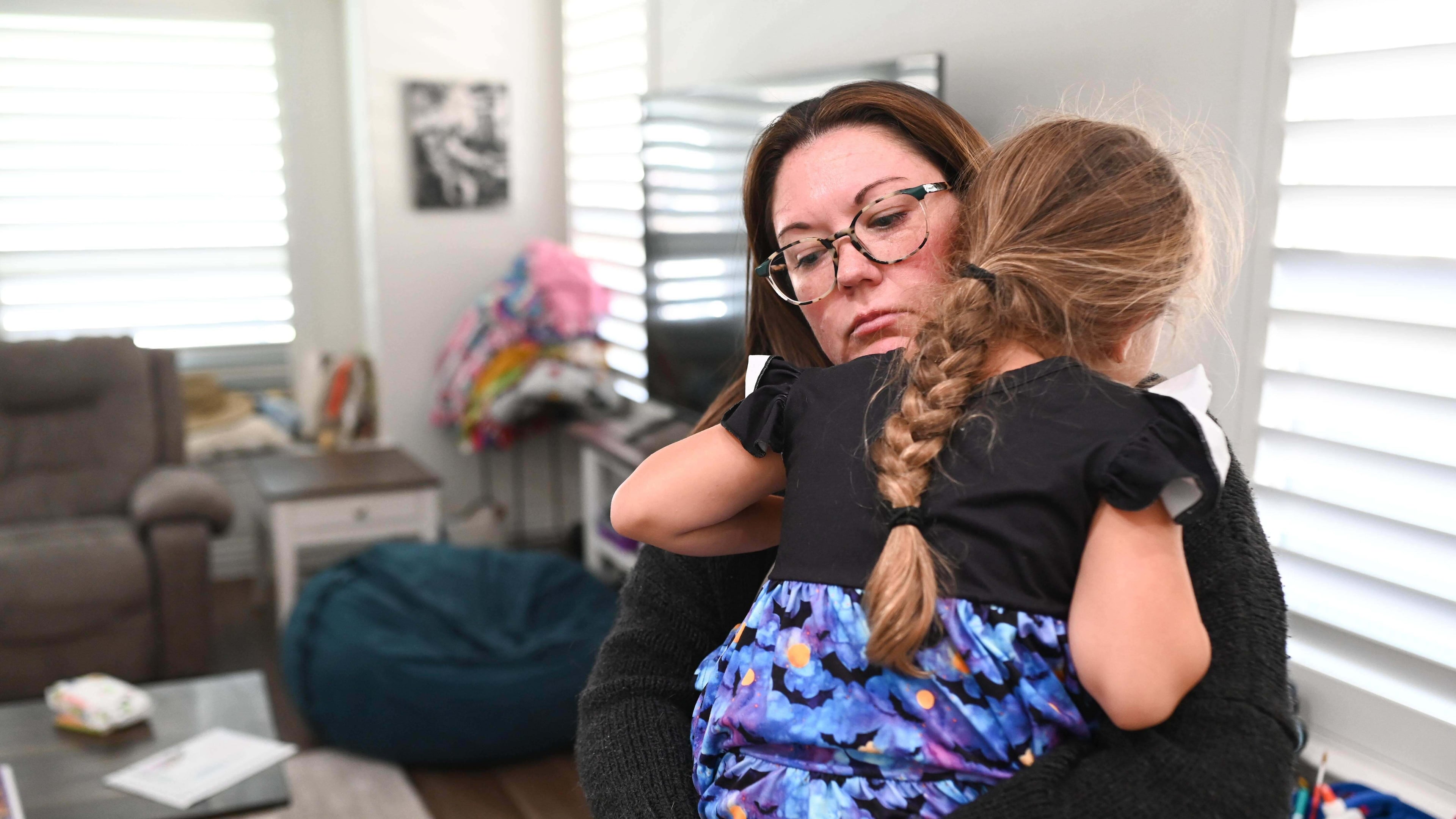 Jennifer Bittner holds her 6-year-old daughter Amelia at their home on Wednesday, Oct. 29, 2025, in Pflugerville, Texas. (AP Photo/Jack Myer)