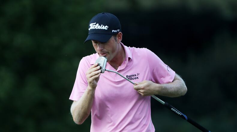 Tour Championship co-leader  Webb Simpson gives his putter a good talking to on East Lake’s 16th green Friday.  (Sam Greenwood/Getty Images)