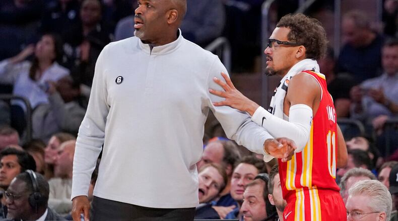 Atlanta Hawks coach Nate McMillan, left, prepares to send guard Trae Young (11) back into the game during the second half of the team's NBA basketball game against the New York Knicks, Wednesday, Nov. 2, 2022, at Madison Square Garden in New York. The Hawks won 112-99. (AP Photo/Mary Altaffer)