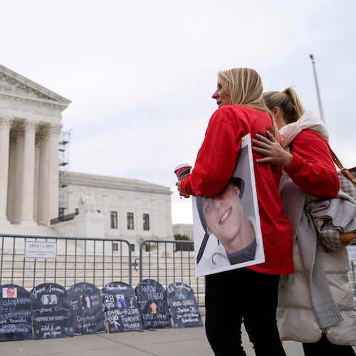 FILE - Jen Trejo holds a photo of her son Christopher as she is comforted outside the Supreme Court Dec. 4, 2023, in Washington. (AP Photo/Stephanie Scarbrough, File)