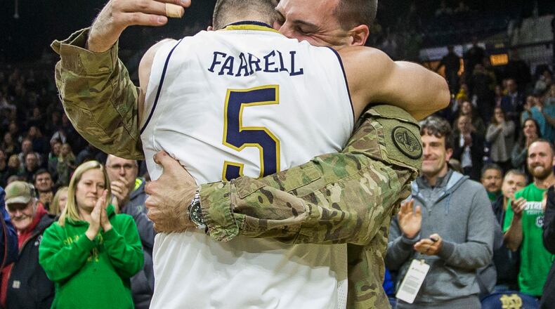Notre Dame men's basketball player Matt Farrell (5) is surprised by his brother Bo Farrell on the court following Notre Dame's 77-62 victory over Colgate in an NCAA college basketball game Monday, Dec. 19, 2016, in South Bend, Ind. Bo Farrell is serving in the U.S. Army and came home from being deployed to Afghanistan. (AP Photo/Robert Franklin)