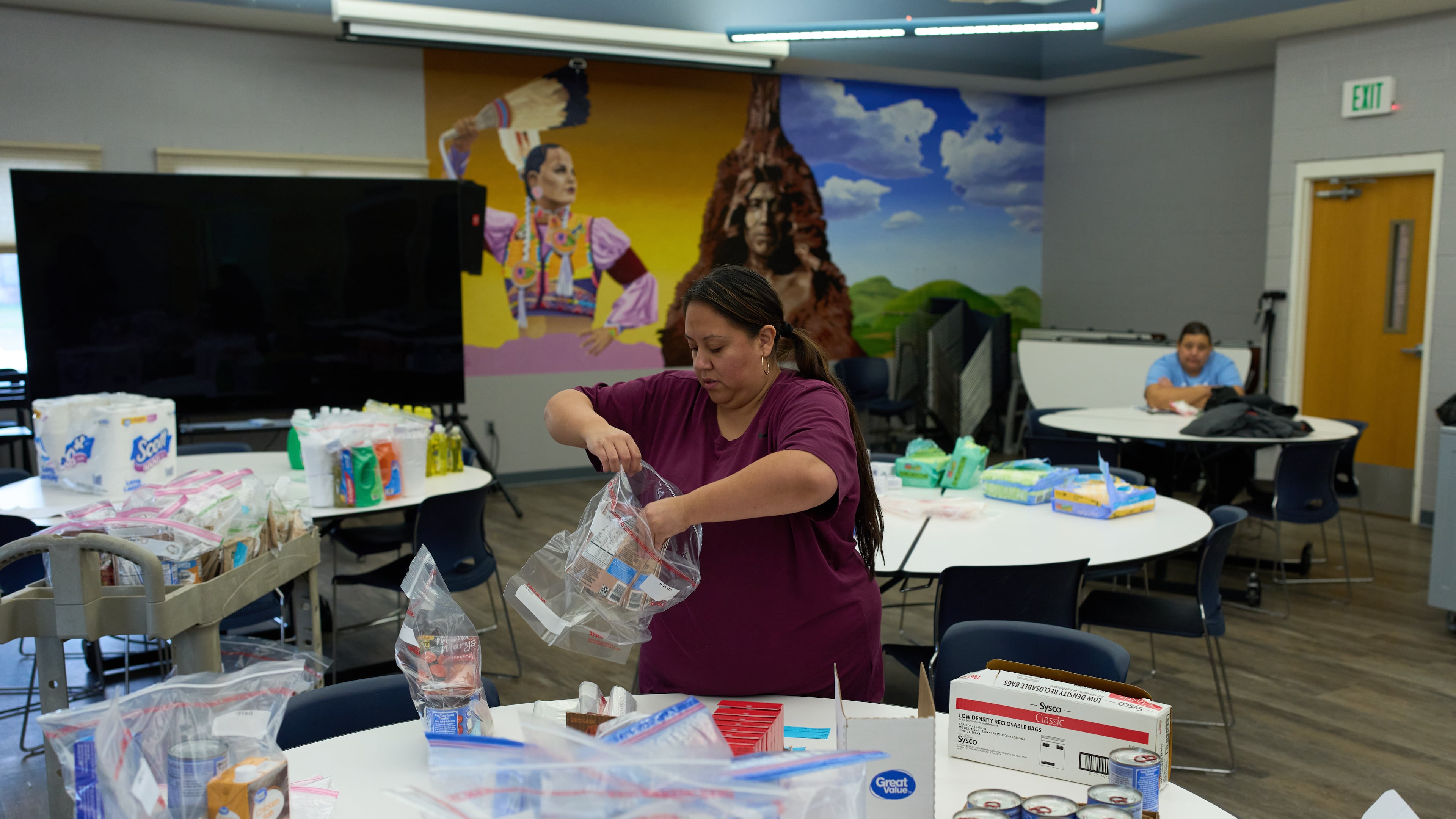 Carla Teran helps prepare bagged meals for a food bank for students at Nueta Hidatsa Sahnish College, Thursday, Oct. 30, 2025, in New Town, N.D. (AP Photo/John Locher)