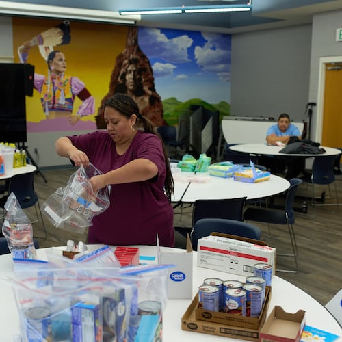 Carla Teran helps prepare bagged meals for a food bank for students at Nueta Hidatsa Sahnish College, Thursday, Oct. 30, 2025, in New Town, N.D. (AP Photo/John Locher)