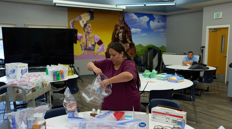 Carla Teran helps prepare bagged meals for a food bank for students at Nueta Hidatsa Sahnish College, Thursday, Oct. 30, 2025, in New Town, N.D. (AP Photo/John Locher)