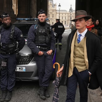 FILE - Pedro Elias Garzon Delvaux, right, walks past as police officers block an entrance to the Louvre after thieves carried out a daylight raid on French crown jewels, in Paris, Oct. 19, 2025. (AP Photo/Thibault Camus, File)