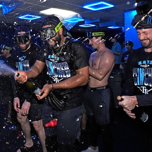 Tampa Bay Rays' Junior Caminero spreays champagne on teammates after the team clinched a playoff spot with a win over the Houston Astros during a baseball game Friday, Sept. 11, 2026, in St. Petersburg, Fla. (AP Photo/Chris O'Meara)