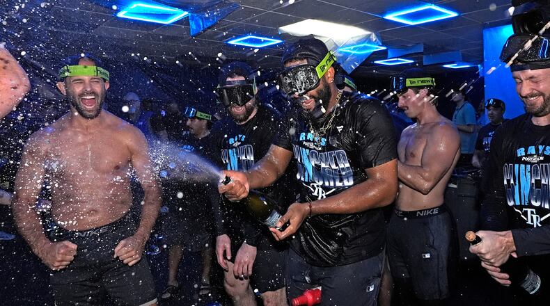 Tampa Bay Rays' Junior Caminero spreays champagne on teammates after the team clinched a playoff spot with a win over the Houston Astros during a baseball game Friday, Sept. 11, 2026, in St. Petersburg, Fla. (AP Photo/Chris O'Meara)