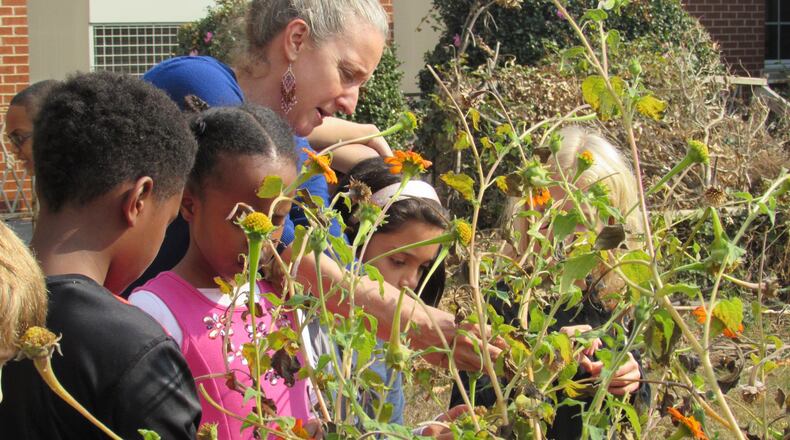 Joanna Gerber, environmental science teacher at the Friends School of Atlanta, works with second graders in the school’s milkweed garden that attracts monarch butterflies. The school was recently designated a waystation on the butterflies’ migratory route.
