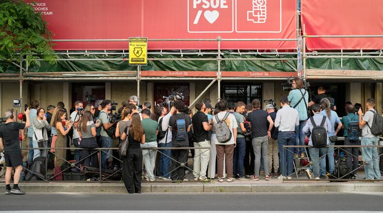 Journalists gather outside the headquarters of Spain's ruling Socialist Party as police search the building in Madrid, Wednesday, May 27, 2026. (AP Photo/Bernat Armangue)