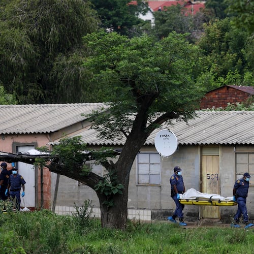Police officers carry the body of a person on a stretcher after a mass shooting at a bar near Pretoria, South Africa, Saturday, Dec. 6, 2025. (AP Photo)