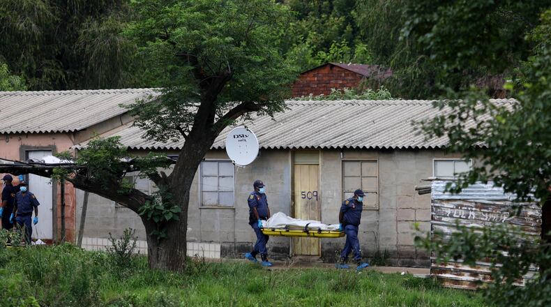 Police officers carry the body of a person on a stretcher after a mass shooting at a bar near Pretoria, South Africa, Saturday, Dec. 6, 2025. (AP Photo)