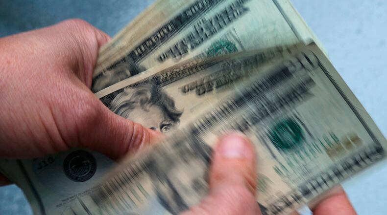 FILE- In this June 15, 2018, file photo, twenty dollar bills are counted in North Andover, Mass. (AP Photo/Elise Amendola, File)