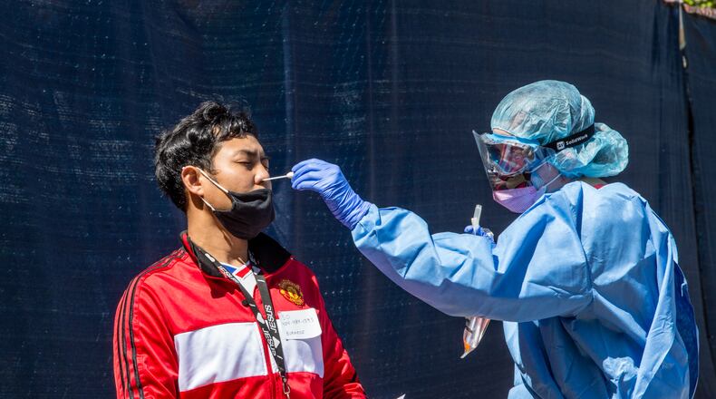A nurse takes a sample for a coronavirus test earlier this year in Clarkson. Gwinnett County Public Schools will begin to pilot voluntary random COVID-19 testing at the end of this month at Norcross and Paul Duke STEM High Schools and the eight elementary and middle schools that feed into them. (Jenni Girtman for the Atlanta Journal-Constitution)