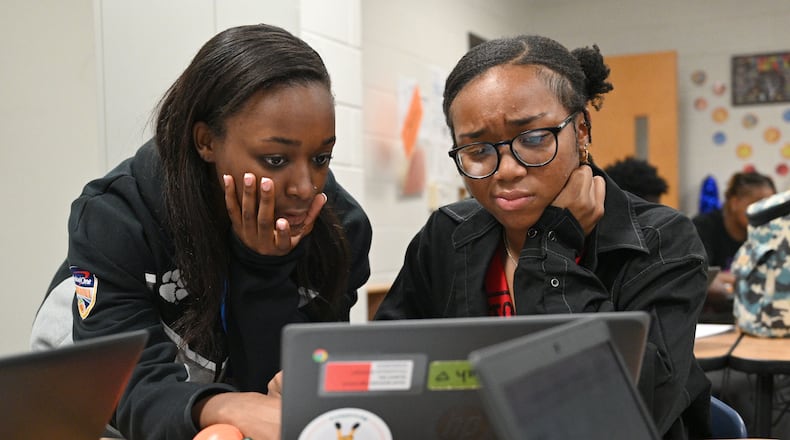 Alijah Gabriel (left), a South Gwinnett High School senior and teacher intern, helps Dayjah Bailey, 17, during a pre-calculus class Sept. 13, 2023. (Hyosub Shin / Hyosub.Shin@ajc.com)