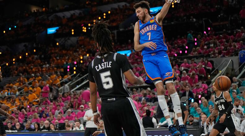 Oklahoma City Thunder center Chet Holmgren (7) hangs on the rim next to San Antonio Spurs guard Stephon Castle (5) after a dunk during the second half of Game 3 in the Western Conference finals NBA basketball playoffs series Friday, May 22, 2026, in San Antonio. (AP Photo/Ashley Landis)