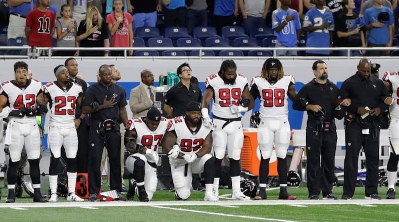 Atlanta Falcons defensive tackles Grady Jarrett (97) and Dontari Poe (92) take a knee during the national anthem before an NFL football game. Carlos Osorio/AP