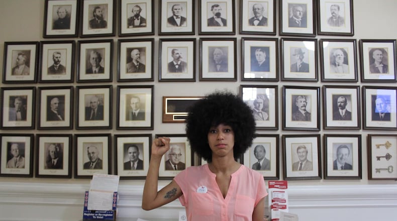Mariah Parker, a 26-year-old University of Georgia doctoral student and newly-elected Athens-Clarke County Commissioner, stands before portraits of former elected officials inside Athens City Hall. Photo courtesy Raphaëla Alemán.