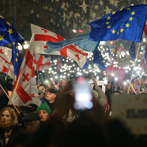 Demonstrators with Georgian and EU flags gather in the Georgian capital of Tbilisi, on Friday, Nov. 28, 2025, to mark 365 days of non-stop protests against the government's decision to halt talks on joining the European Union. (AP Photo/Zurab Tsertsvadze)