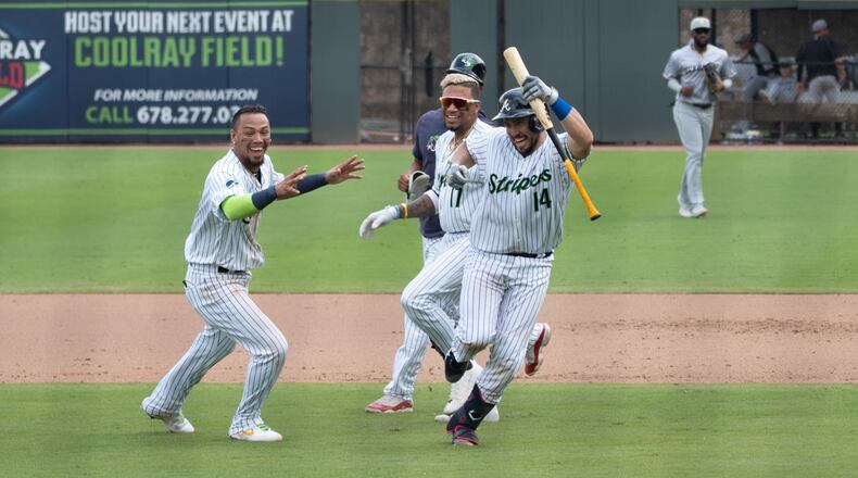 Catcher Travis d'Arnaud (14) celebrates with Gwinnett teammates after hitting a walk-off hit that brought in the winning run off 4-3 victory over Charlotte in the first game of a doubleheader Sunday, Aug. 9, 2021, at Coolray Field in Lawrenceville. (Jamie Spaar/Gwinnett Stripers)