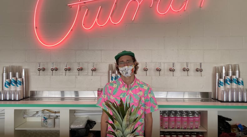 Co-founder and brewer Josh Miller stands behind the bar at the Outrun taproom in Stone Mountain. (Bob Townsend for The Atlanta Journal-Constitution)