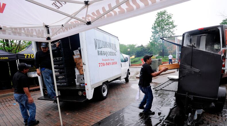 Williamson Bros. barbecue employees put away their wood smokers as the rain forces the cancellation of the Spring Jonquil Festival at the Village Green in downtown Smyrna on April 28, 2013.