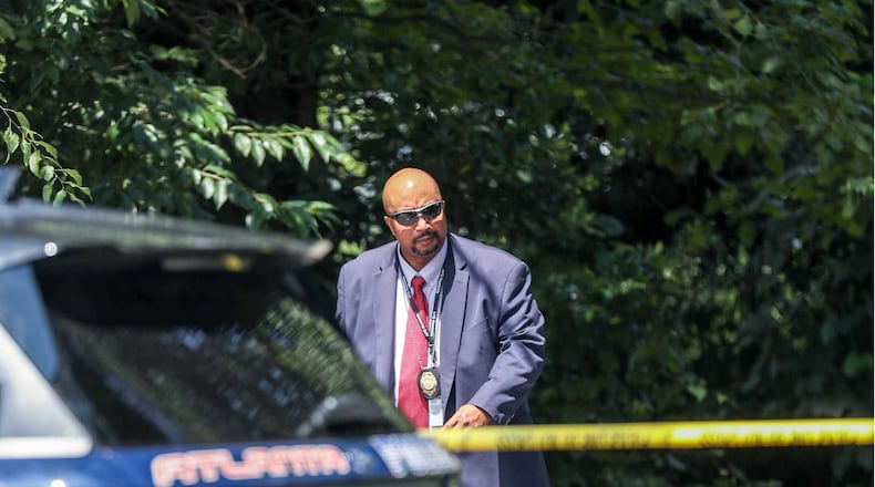 Members of the Atlanta Police Department investigate a scene at the corner of Lakewood Avenue and Terrace Way in southeast Atlanta’s Lakewood Heights community, where police discovered the body of a woman who had been reported kidnapped hours earlier.