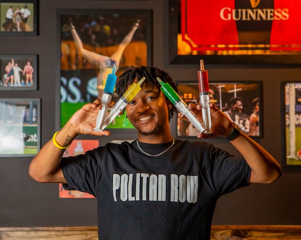 A server holds four "juicers," which are Jell-O shots served in syringes and named for certain sports figures, from Streakers Sports Pub. (Courtesy of Streakers Sports Pub)