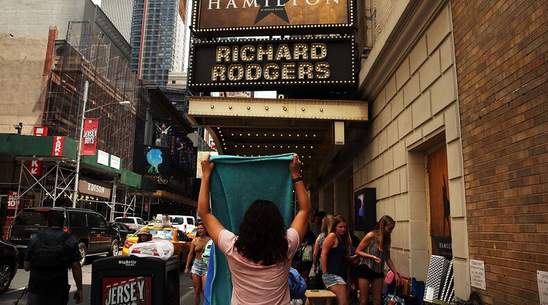 NEW YORK, NY - JUNE 21: People, many who have been there for days, wait in line with dozens of others for tickets for the popular Broadway show Hamilton on June 21, 2016 in New York City. The Tony Award-winning Broadway hit has drawn huge crowds to the Richard Rogers theater in tin he hopes of getting increasingly scarce and expensive tickets. Carrying bed rolls, pillows and take-out food containers, many fans of the musical wait days in the heat and rain for a chance to get a cancellation ticket which are offered to the public once they're declined by members of the cast and crew. (Photo by Spencer Platt/Getty Images)
