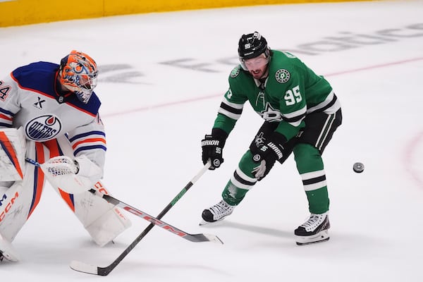 Edmonton Oilers goaltender Stuart Skinner (74) moves the puck as Dallas Stars center Matt Duchene (95) close in during the third period in Game 1 of the Western Conference finals in the NHL hockey Stanley Cup playoffs Wednesday, May 21, 2025, in Dallas. (AP Photo/LM Otero)