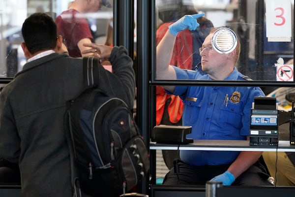 FILE - A Transportation Security Administration agent signals for the next airline passenger in line at a security checkpoint in Chicago's O'Hare International Airport Friday, May 26, 2023. (AP Photo/Charles Rex Arbogast, File)