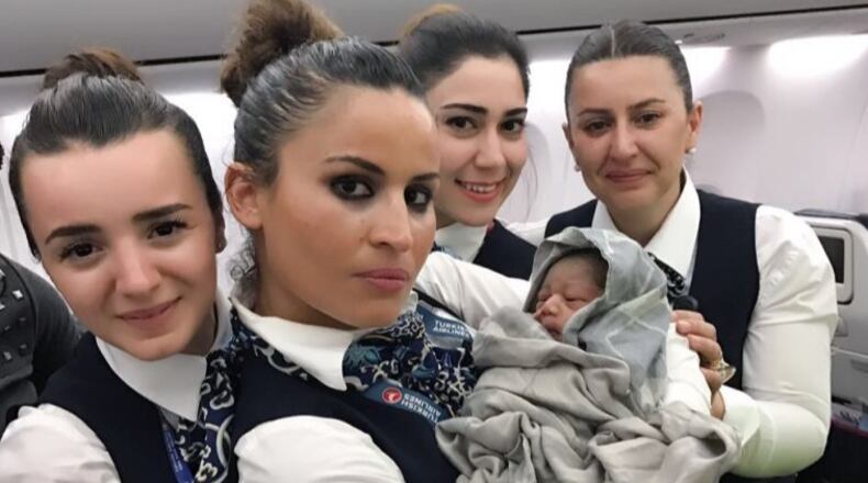 A cabin crew of Turkish Airlines pose for a photo with a baby born in a plane during a flight from Conakry to Ouagadougou to Istanbul on April 7, 2017 in the air. (Photo by Turkish Airlines / Handout/Anadolu Agency/Getty Images)