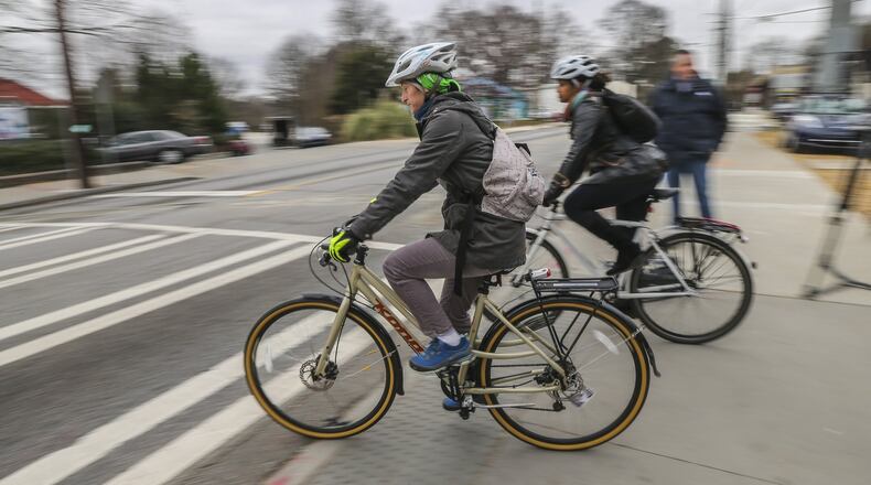 Bike riders enter the intersection at 10th and Monroe Drive from the Beltline on their way to City Hall following a gathering calling for change to the intersection on Feb. 15, 2016, after a Grady High School freshman was hit and killed while riding her bicycle. JOHN SPINK /JSPINK@AJC.COM