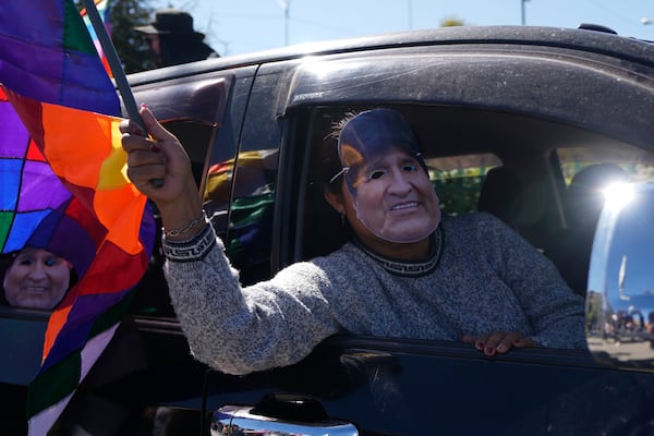 A man wearing a mask depicting former President Evo Morales tales part in a caravan to the Electoral Tribunal offices in El Alto, Bolivia, Friday, May 16, 2025. (AP Photo/Juan Karita)