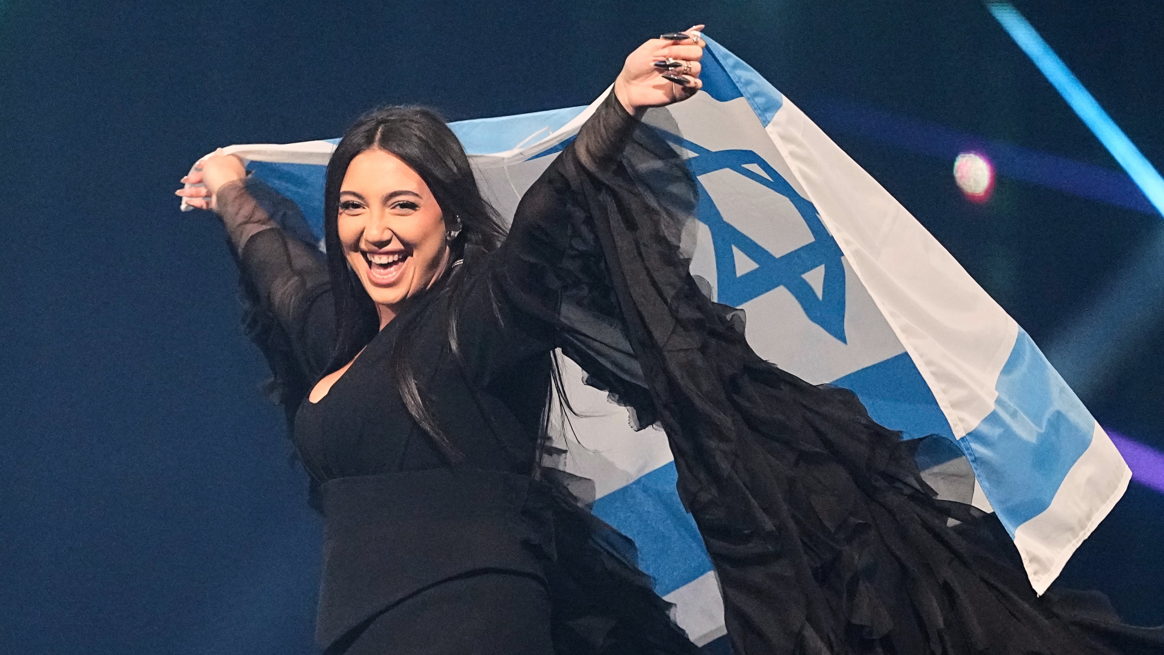 FILE - Singer Yuval Raphael, from Israel, holds the national flag during a dress rehearsal for the Grand Final of the 69th Eurovision Song Contest, May 16, 2025, in Basel, Switzerland. (AP Photo/Martin Meissner, File)
