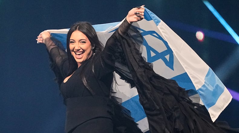 FILE - Singer Yuval Raphael, from Israel, holds the national flag during a dress rehearsal for the Grand Final of the 69th Eurovision Song Contest, May 16, 2025, in Basel, Switzerland. (AP Photo/Martin Meissner, File)