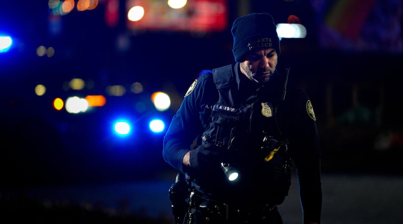 A police officer searches for evidence after a woman was shot in northeast Atlanta early Tuesday morning.