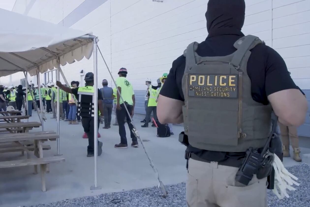 This image from video provided by U.S. Immigration and Customs Enforcement via DVIDS shows manufacturing plant employees being escorted outside the Hyundai Motor Group’s electric vehicle plant on Thursday, Sept. 4, 2025, in Ellabell, Ga. One of the workers arrested by ICE in the raid has filed a $2 million legal claim against the agency. (Corey Bullard/U.S. Immigration and Customs Enforcement via AP)
