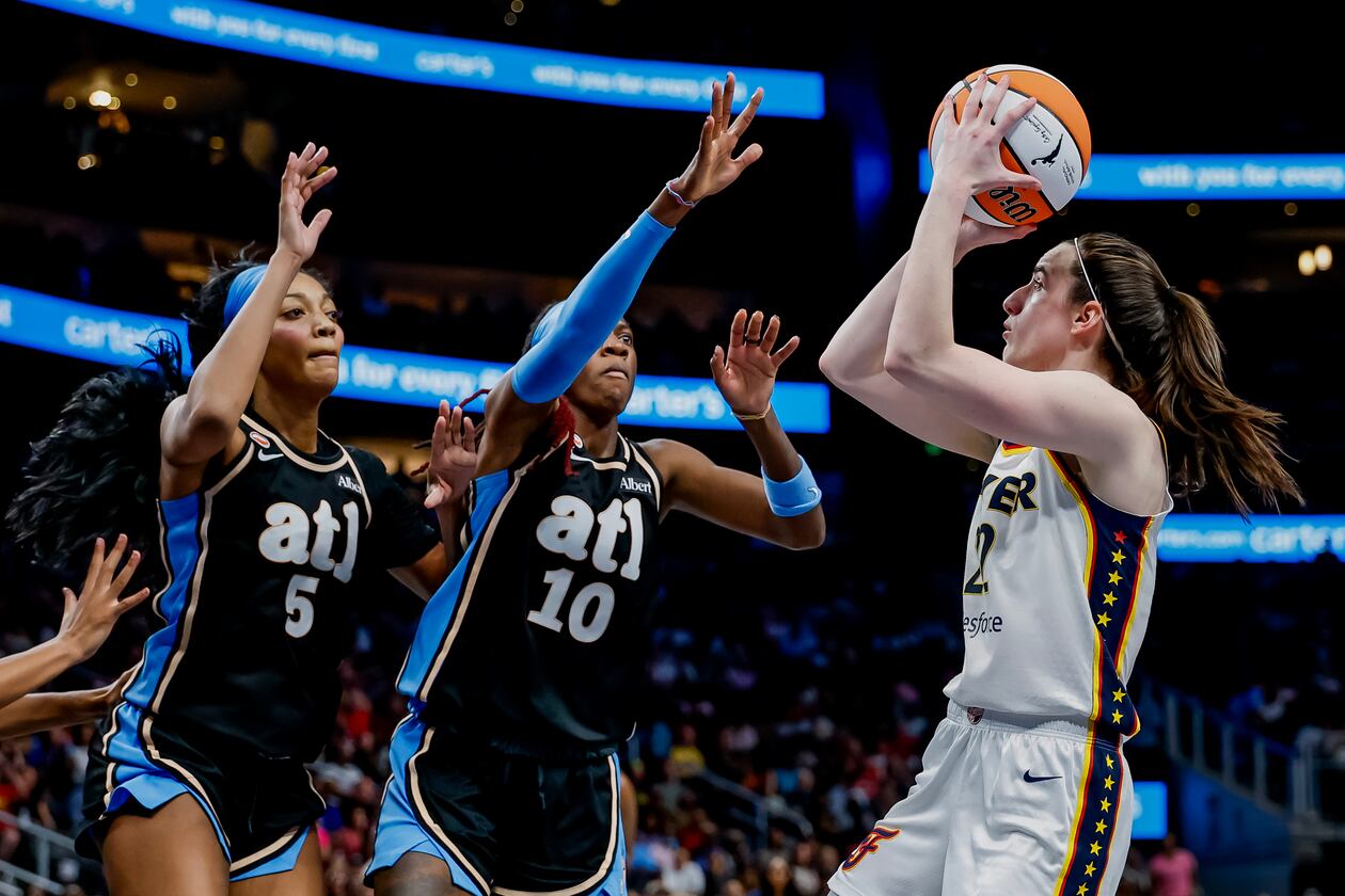 Atlanta Dream forward Angel Reese (left) and guard Rhyne Howard defend against Indiana Fever guard Caitlin Clark during Sunday's WNBA game in Atlanta. (Erik S. Lesser for the AJC)