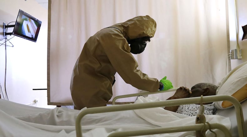 A member of the Georgia Army National Guard infection control team from the 265th Chemical Battalion compassionately cleans the bed railings of a resident without waking him at Legacy Transitional Care while disinfecting the room where COVID-19 has taken its toll on April 19, 2020, in Atlanta. Curtis Compton ccompton@ajc.com
