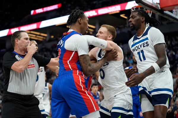 CORRECTS TO PISTONS FORWARD RONALD HOLLAND II NOT CENTER JALEN DUREN - Detroit Pistons forward Ronald Holland II, center left, and Minnesota Timberwolves guard Donte DiVincenzo, center right, fight during the first half of an NBA basketball game, Sunday, March 30, 2025, in Minneapolis. (AP Photo/Abbie Parr)