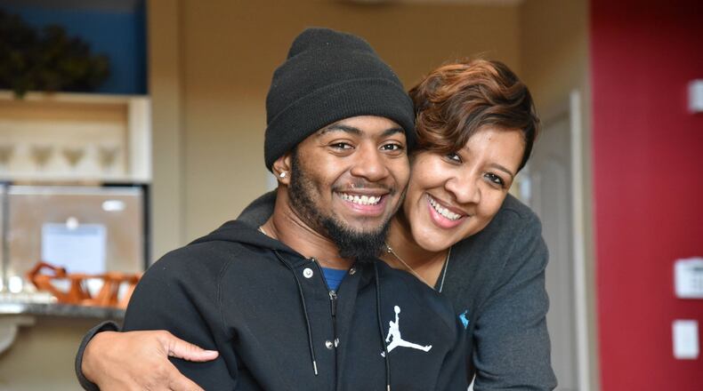 Tish Gales and her stepson Devon strike a pose inside their Atlanta condominium recently. (Hyosub Shin/hshin@ajc.com)