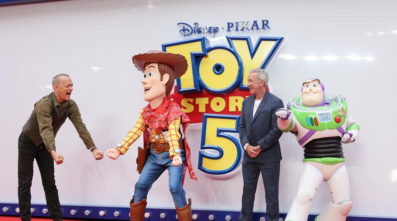 Tom Hanks, left, and Tim Allen pose for photographers with people costumed as the characters Woody and Buzz Lightyear upon arrival at a launch event for the film 'Toy Story 5' on Thursday, May 28, 2026, in London. (Photo by Millie Turner/Invision/AP)
