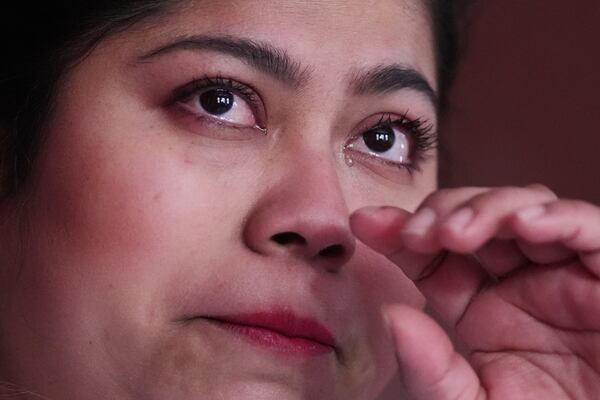 While wiping away a tear, Marilu Domingo Ortiz, whose husband was taken into custody by ICE agents after they smashed a window of their family car, describes the arrest during an interview at their home, Wednesday, April 16, 2025, in New Bedford, Mass. (AP Photo/Charles Krupa)